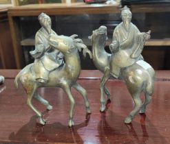 A pair of 19th century Chinese brass incense burners in the form of sages riding animals, heights