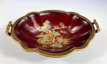 An oval 1930's Crown Devon "Rouge Royal" style red lustre bowl decorated with Chinoiserie scenes,