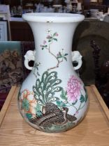 A Chinese famille rose vase decorated with polychrome peacock and flowers, with elephant handles,