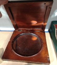 A circular concave mirror in mahogany case, possibly a ship's signalling mirror