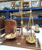 A large 19th century brass balance scale with weights on mahogany plinth and a smaller postal