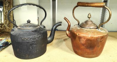 A large cast iron kettle and a similar copper kettle