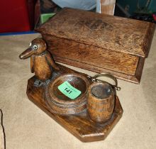 A carved desk top ash tray in the form of a penguin with barrel, an oak box and a brass paper