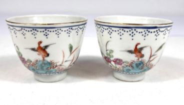 A pair of Chinese porcelain tea bowls finely decorated with flowers and polychrome birds, blue