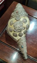 An unusual antique Tibetan conch shell trumpet mounted with white metal with detailed embossed