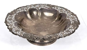 A hallmarked silver ribbed circular shallow dish with vine border, on circular foot, Sheffield 1936,