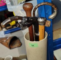 A walking stick with dog's head handle and 5 other vintage sticks and a bamboo wall pocket, 76cm