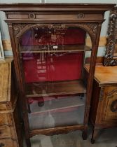 A narrow Edwardian mahogany full height display cabinet enclosed by single door on square legs, 4