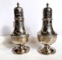 A hallmarked silver pair of baluster pepper pots with ornate chased decoration, London 1899, 4.5oz