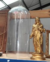 A 19th century metal figure of Christ under a glass dome.