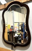 A large wall mirror in shield shaped mahogany frame