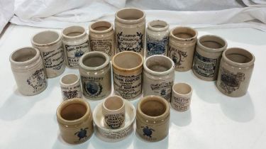 A collection of stoneware jars with later transfer advertising labels.