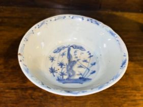 A Chinese possibly ming period blue and white bowl with plants and flowers, (rim restored)