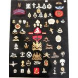 A collection of Military badges set on cardboard metal and cloth badges etc