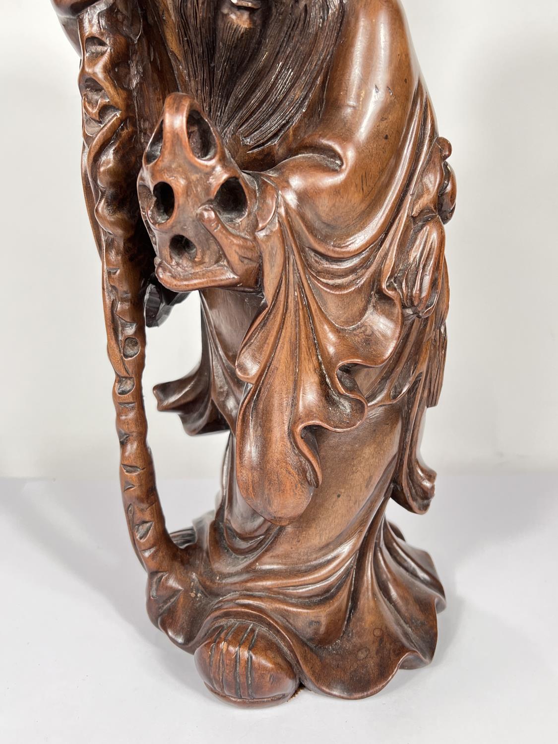 A Chinese hardwood carving of a sage with stick and fruit, ht. 50cm - Image 3 of 4