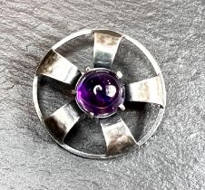 An Arts & Crafts white metal brooch set purple circular cabochon stone, possibly Scottish