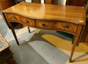 A Regency style mahogany side table with crossbanded decoration, serpentine front, 2 drawers and