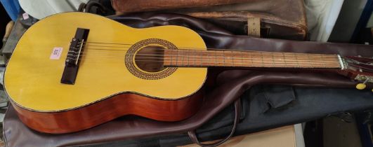 A nylon strung acoustic guitar in soft case; an electric guitar gig bag