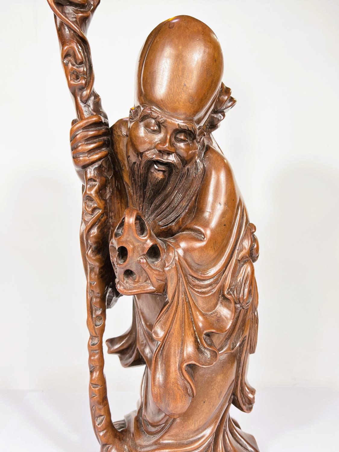 A Chinese hardwood carving of a sage with stick and fruit, ht. 50cm - Image 2 of 4