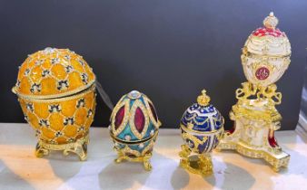 4 modern Faberge style gilt and bejewelled eggs on stands, one with a gilt coach inside and one