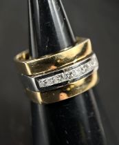 A gent's yellow and white metal dress ring, broad shank, the central white band set with 8