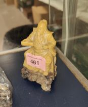 A Chinese jade coloured soapstone carving of a bearded deity, on different coloured plinth,