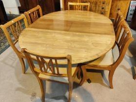 A Beresford & Hicks reproduction yew wood dining suite comprising circular extending pedestal table,