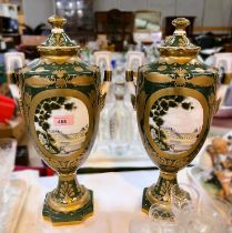 A Continental pair of large covered vases, urn shaped with panels depicting chateaux, etc.,