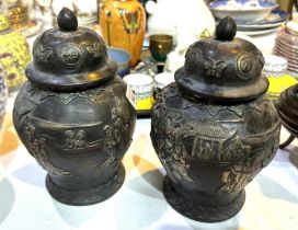 A pair of Chinese bronze lidded vases with silvered relief decoration of domestic scenes, text to