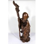 A Chinese hardwood carving of a sage with stick and fruit, ht. 50cm