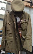 A WWII period Royal Army Ordinance Corps uniform with buttons and badges to collar and cap,