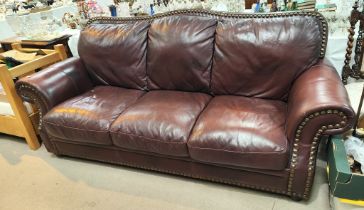 A large leather three seater settee in brown hide, with studded boarder decoration, length 225cm