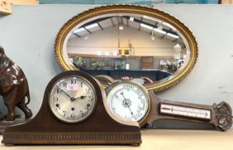 A carved oak aneroid barometer with thermometer; an oak cased chiming mantle clock; an oval gilt