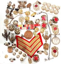 A collection of various military badges and buttons including cloth stripes etc