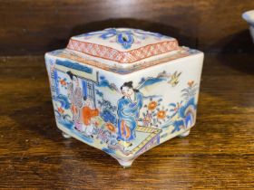 A Chinese lidded pit with polychrome domestic scenes, diamond shape with pierced lid, length 10.5cm