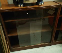 A 1950's pair of 3 height walnut bookcases with sliding glass doors