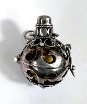 An unusual white metal pierced antique cat bell set with moonstone type stone set to the top