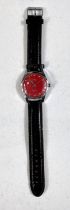 A 1960's gent's unusual wristwatch, steel cased with red dial and mechanical movement, on later