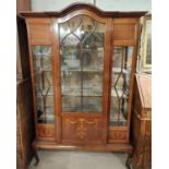 An Edwardian Sheraton dome top, full height mahogany display cabinet with moulded frieze, and glazed