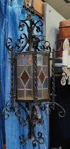 A Gothic style wrought metal hanging lantern with coloured glass panels