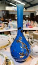 An oriental large bulbous vase with slender neck, deep blue glaze with gilded raised decoration,