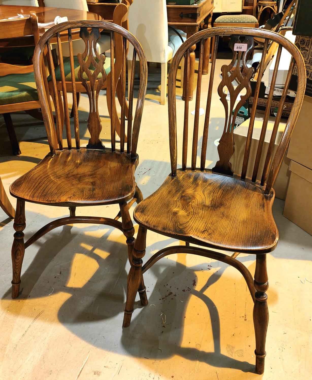 A pair of elm wheel back dining chairs in the style of Titchmarsh & Goodwin