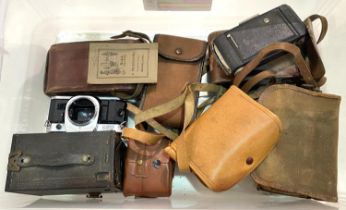 A Canon AE-1 SLR camera and a collection of vintage box and other cameras.