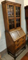 An early 20th century oak full height bureau bookcase with three drawers, fall front and astragal