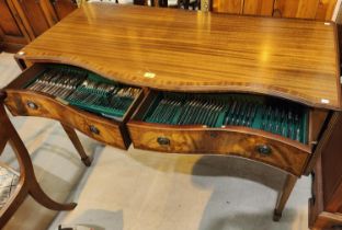 A Regency style mahogany side table with crossbanded decoration, serpentine front, 2 drawers and