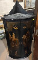 A Georgian mahogany bow front corner cupboard decorated in black lacquer with chinoiserie scenes,