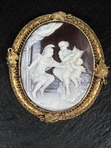 A cameo brooch depicting classical Greek figures in an intricate yellow metal setting, height 9.25