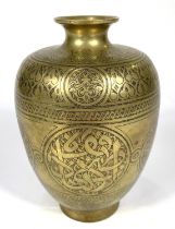 An Islamic brass vase with etched decoration to the outside, tapering and flaring rim, ht. 14.5cm