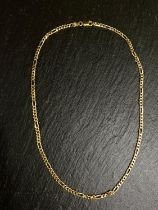 A yellow metal chain formed from alternating multiple elongated flattened curb links, stamped 585,