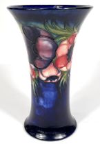 Moorcroft: A William Moorcroft signed vase, dark blue ground with anemone flowers, waisted body with